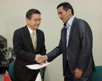 Cérémonie de signature des contrats de dons pour les projets de l'Aide non-remboursable aux micro-projets locaux contribuant à la sécurité humaine (17/03/2014) - l'Ambassadeur Kurokawa remettant le contrat au représentant de l'Association Bassin Guir de développement et protection de l'environnement