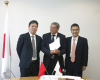 Cérémonie de signature des contrats de dons pour les projets de l'Aide non-remboursable aux micro-projets locaux contribuant à la sécurité humaine (25/03/2015) - l'Ambassadeur Kurokawa remettant le contrat au représentant de l'Association Al Hamd des Hémodialysés et des maladies chroniques